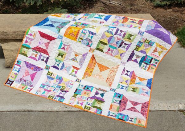 A quilt that is sitting on the ground.