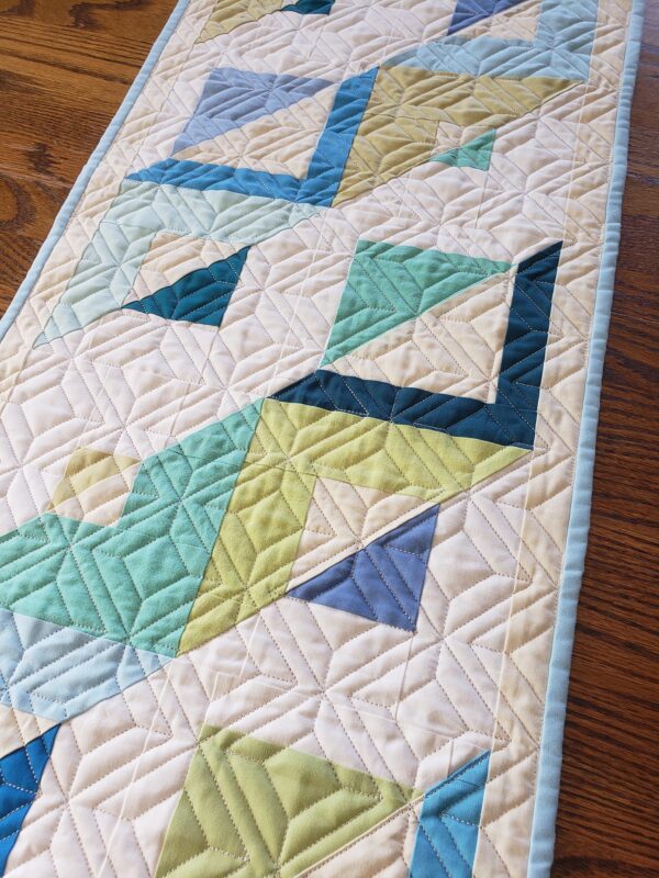 A table runner with blue and green designs on it.